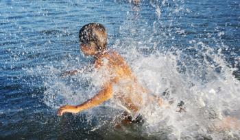 Royalty Free Photo of a Boy Splashing in Water